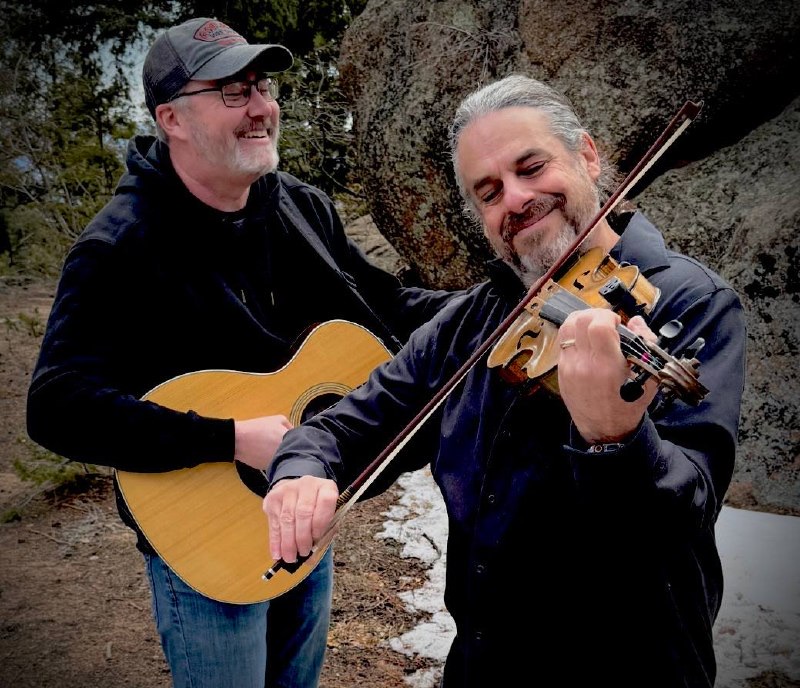 Blood Brothers duo: Lance on guitar and Jay on fiddle among mountain boulders
